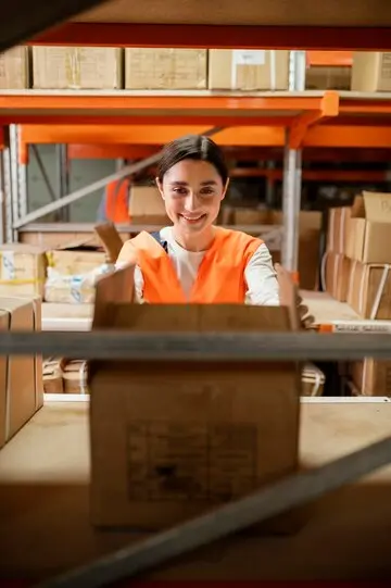 Mujer del equipo de seguridad trabajando, vestida con equipo de protección y monitoreando un área.